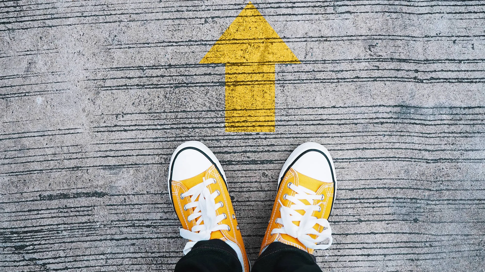 A path moving forward. A selfie of two feet with an arrow pointing forward